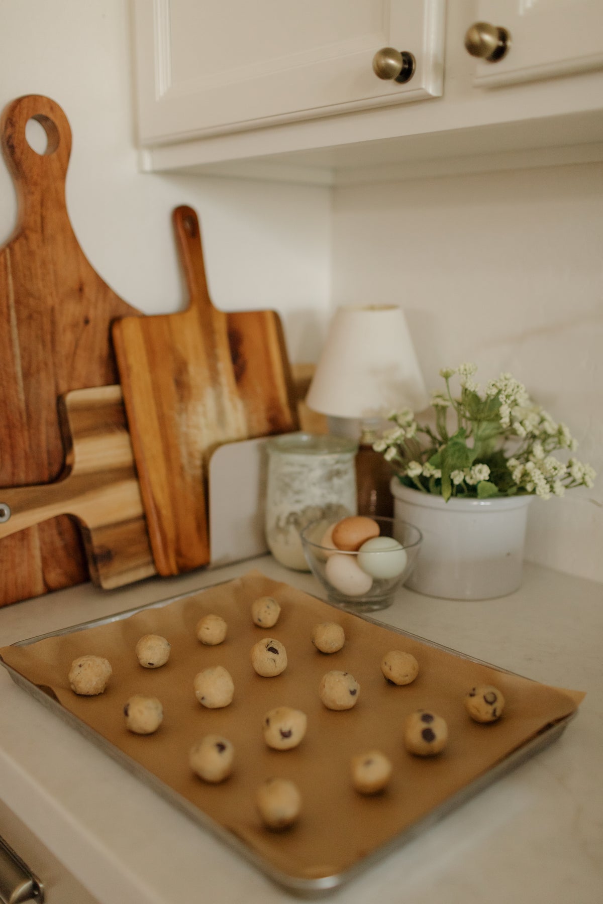 A tray of cookie dough by the cutting boards and flowers