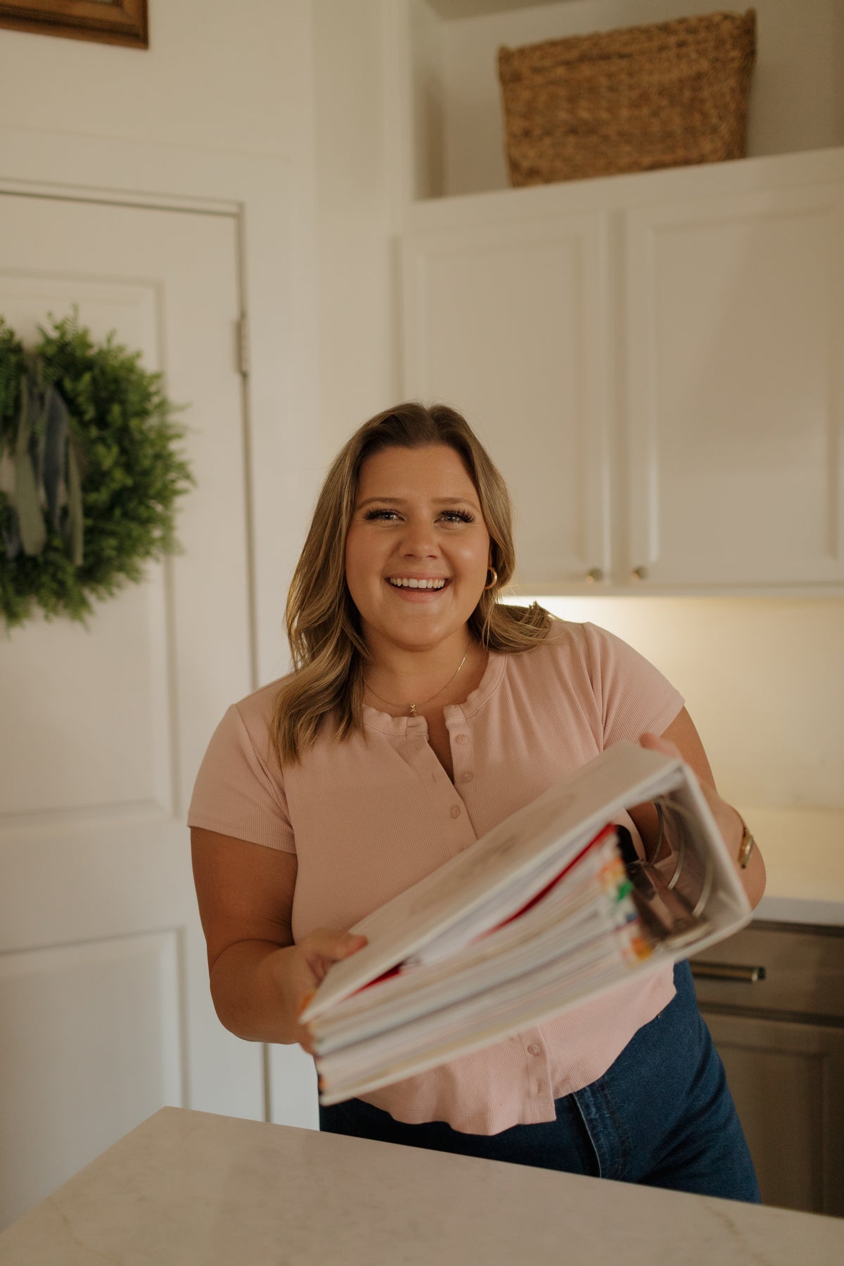 Abbie laughing in her kitchen with her recipe binder