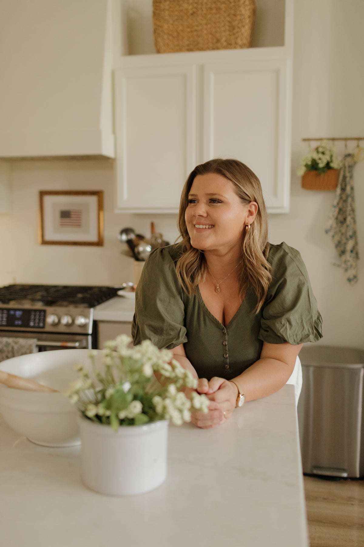 Abbie Flake at her kitchen counter with fresh daisies