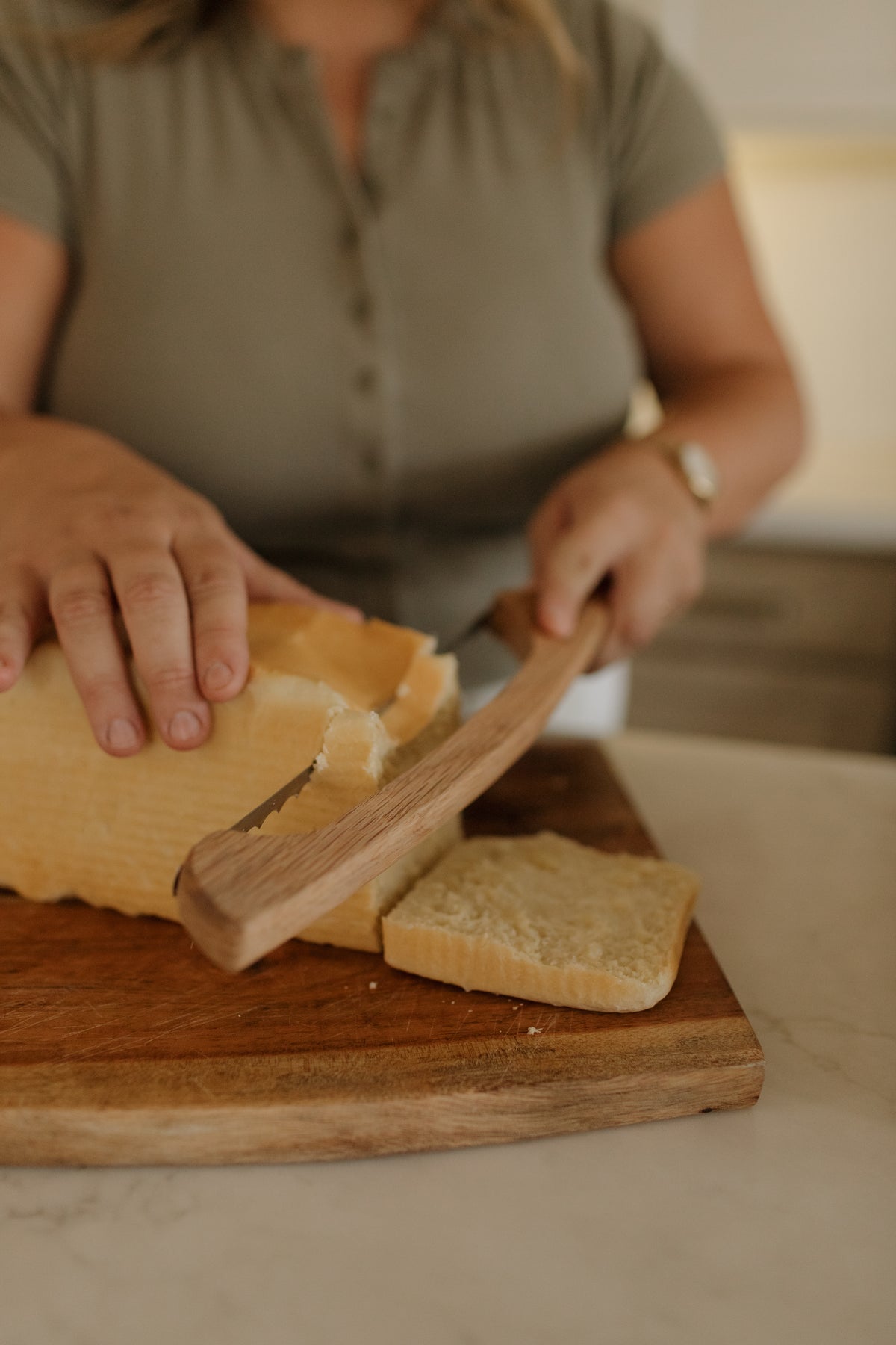 Abbie slicing a homemade loaf on a wooden board
